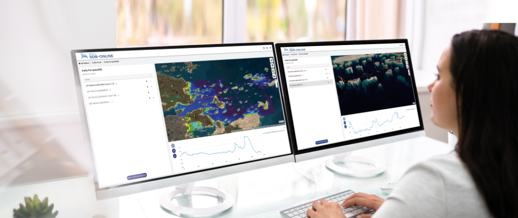 woman in front of 2 screens looking at satellite derived bathymetry of EOMAP