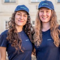 2 new employees at EOMAP wearing the company shirts and caps